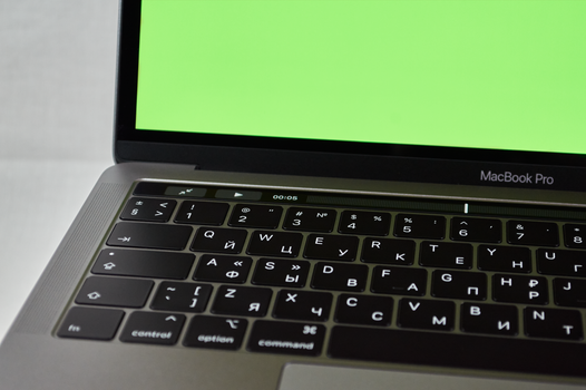 MacBook Air M4 open op bureau met iPhone en AirPods ernaast