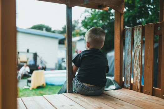 Ouders zitten op een terras naast een speeltuin in Limburg terwijl kinderen buiten spelen