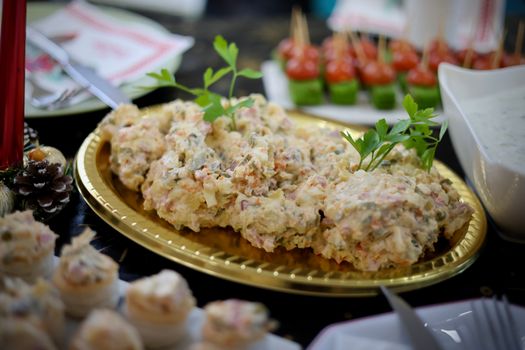 Huisgemaakte Limburgse koude schotel met aardappelen, ei, ham, augurk en peterselie op een serveerschaal