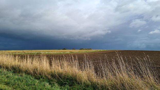 Donkere onweerslucht boven de Maas bij Roermond tijdens noodweer in Limburg vandaag