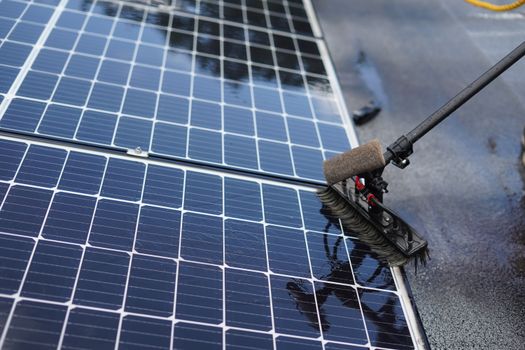 Monteur reinigt zonnepanelen op een woning in Limburg met telescoopborstel en osmosewater